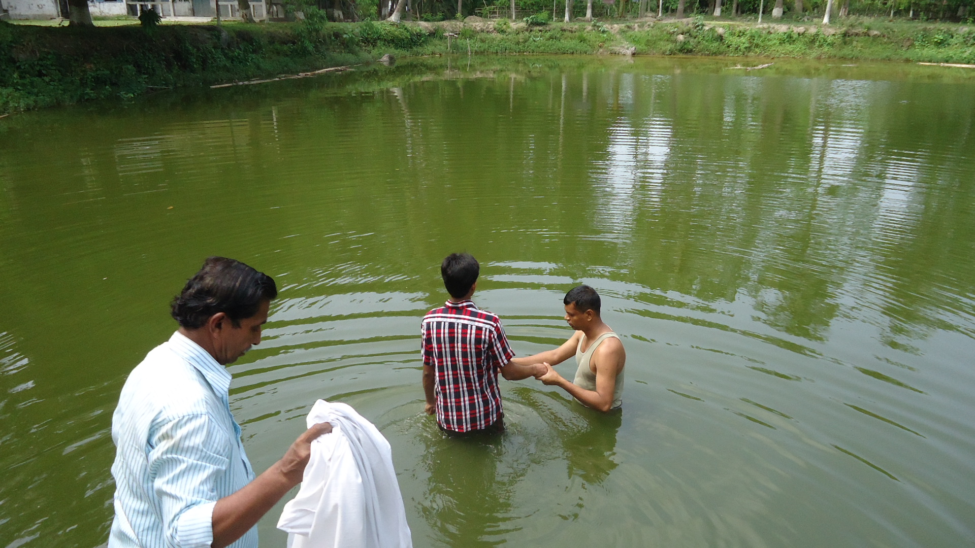 A baptism taking place in a baptismal pool